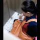 A daring cameraman records an unsuspecting, plump Asian woman pissing and farting repeatedly while sitting on a toilet in a public restroom stall. The farts are wet-sounding, but no plops are heard. Vertical format video. Over 1.5 minutes.